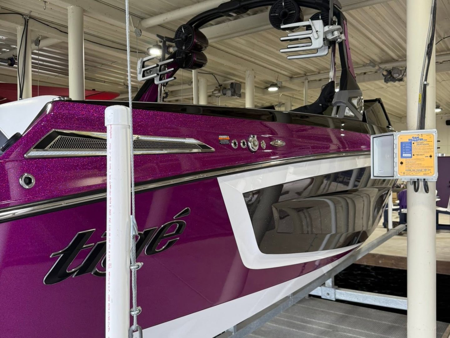 Purple metalflake Tigé wake boat with a high-gloss finish on its lift
